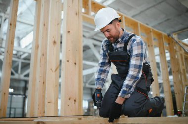 Modern modüler ev. Bir işçi ahşap bir evin inşaatında çalışıyor..