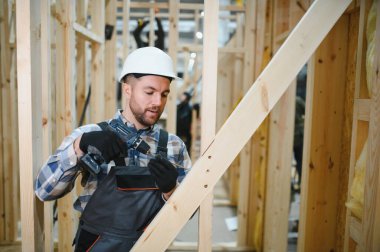 Bir marangoz modüler evler inşaatında çalışır..