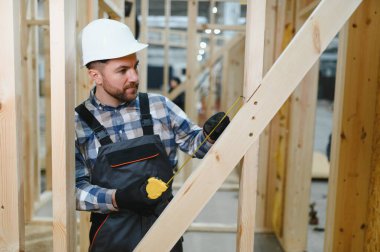 Modüler evlerin yapımı. Üniformalı ve inşaat alanında çalışan erkek inşaat işçisi..