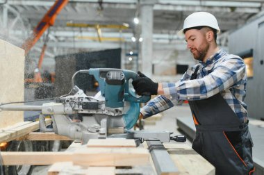 Bir marangoz modüler evler inşaatında çalışır..