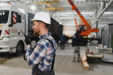 Bir işçi modüler evi kamyona yükleme işlemini kontrol eder. Ulaşım ve teslimat kavramı.