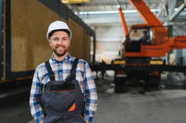 Bir işçi modüler evi kamyona yükleme işlemini kontrol eder. Ulaşım ve teslimat kavramı.