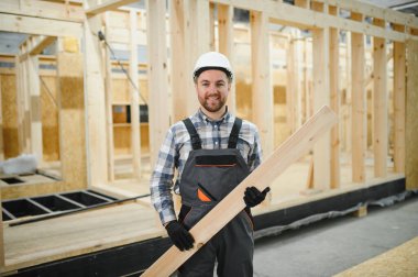 Modern modüler ev. Bir işçi ahşap bir evin inşaatında çalışıyor..