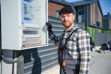 Elektrik mühendisi dış güç dağıtım kutusunu bağlıyor.