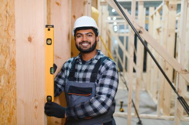 Hintli marangoz modüler evler inşaatında çalışıyor..