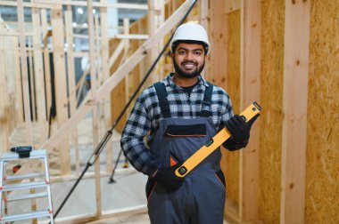 Modüler evlerin yapımı. İnşaat alanında çalışan Hintli inşaat işçisi veya mühendisi.