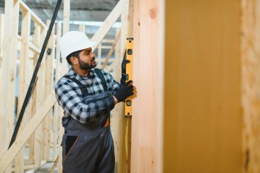 Hintli marangoz modüler evler inşaatında çalışıyor..