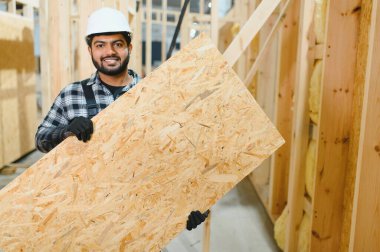 Modüler evlerin yapımı. İnşaat alanında çalışan Hintli inşaat işçisi veya mühendisi.