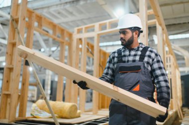 Modüler evlerin yapımı. İnşaat alanında çalışan Hintli inşaat işçisi veya mühendisi.
