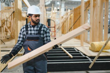 Hintli marangoz modüler evler inşaatında çalışıyor..