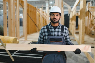 Modüler evlerin yapımı. İnşaat alanında çalışan Hintli inşaat işçisi veya mühendisi.