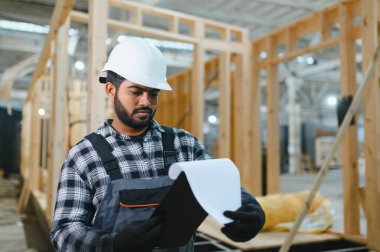 Modüler evlerin yapımı. İnşaat alanında çalışan Hintli inşaat işçisi veya mühendisi.