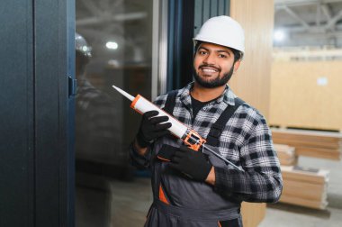 Modern modüler ev. Hintli işçi ahşap bir ev inşaatında çalışıyor..