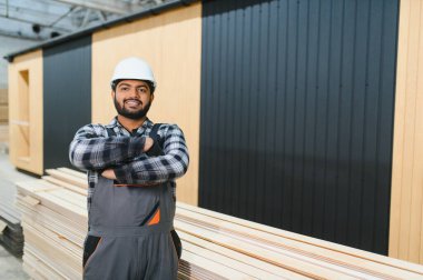 Modern modüler ev. Hintli işçi ahşap bir ev inşaatında çalışıyor..