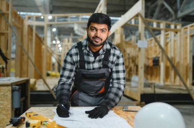 Modüler evlerin yapımı. İnşaat alanındaki Hintli mimar bir plana bakıyor..