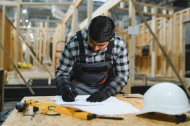 Modüler evlerin yapımı. İnşaat alanındaki Hintli mimar bir plana bakıyor..
