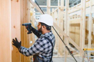 Hintli marangoz modüler evler inşaatında çalışıyor..