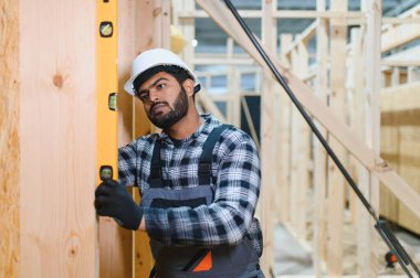 Modüler evlerin yapımı. Üniformalı ve inşaat alanında çalışan Hintli erkek inşaat işçisi..