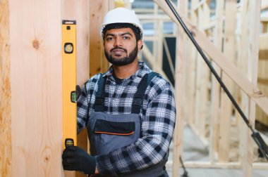 Modern modüler ev. Hintli işçi ahşap bir ev inşaatında çalışıyor..