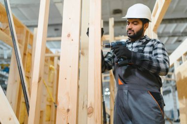 Modüler evlerin yapımı. İnşaat alanında çalışan Hintli inşaat işçisi veya mühendisi.