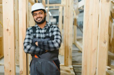 Modern modüler ev. Hintli işçi ahşap bir ev inşaatında çalışıyor..