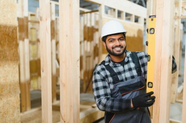 Hintli marangoz modüler evler inşaatında çalışıyor..