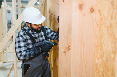 Modüler evlerin yapımı. Üniformalı ve inşaat alanında çalışan Hintli erkek inşaat işçisi..