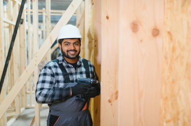 Modüler evlerin yapımı. İnşaat alanında çalışan Hintli inşaat işçisi veya mühendisi.