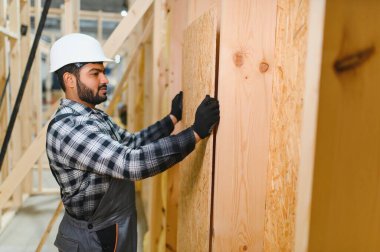 Hintli marangoz modüler evler inşaatında çalışıyor..