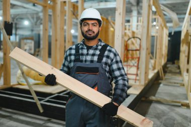 Hintli marangoz modüler evler inşaatında çalışıyor..