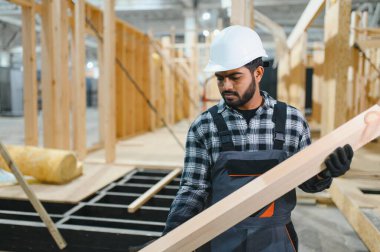 Modern modüler ev. Hintli işçi ahşap bir ev inşaatında çalışıyor..