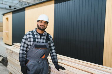 Modüler evlerin yapımı. İnşaat alanında çalışan Hintli inşaat işçisi veya mühendisi.