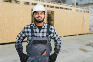 Modern modüler ev. Hintli işçi ahşap bir ev inşaatında çalışıyor..