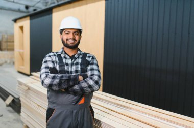 Hintli marangoz modüler evler inşaatında çalışıyor..