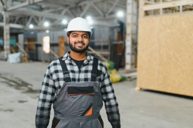 Hintli marangoz modüler evler inşaatında çalışıyor..