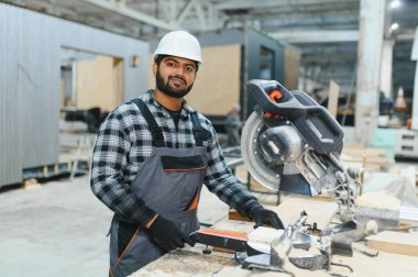 Hintli marangoz modüler evler inşaatında çalışıyor..