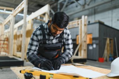 Modern modüler evlerin inşaatı. Hintli mimar bina planlarıyla çalışır..