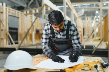 Modern modüler evlerin inşaatı. Hintli mimar bina planlarıyla çalışır..