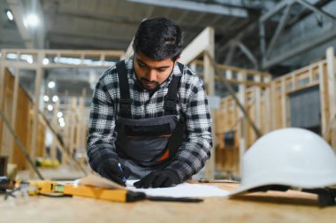 Modern modüler evlerin inşaatı. Hintli mimar bina planlarıyla çalışır..