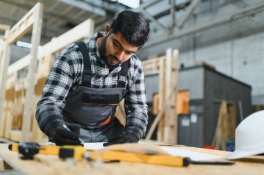 Modern modüler evlerin inşaatı. Hintli mimar bina planlarıyla çalışır..