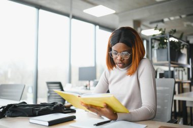 Sınıfta okuyan, üniversite ödevi üzerinde çalışan ciddi bir Afrikalı Amerikalı kız öğrenciye odaklanmış..