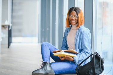 Öğrenci eğitimi, sınav hazırlığı, uzaktan öğrenme, eğitim konsepti. Güzel gülümseyen Afrikalı Amerikalı öğrenci.