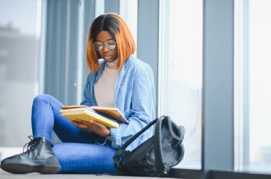 Öğrenci eğitimi, sınav hazırlığı, uzaktan öğrenme, eğitim konsepti. Güzel gülümseyen Afrikalı Amerikalı öğrenci.