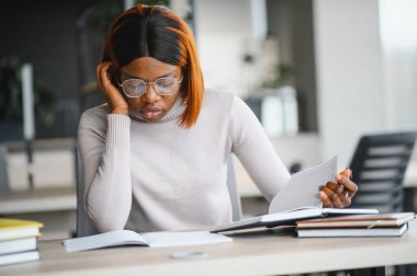 Sınıfta okuyan, üniversite ödevi üzerinde çalışan ciddi bir Afrikalı Amerikalı kız öğrenciye odaklanmış..