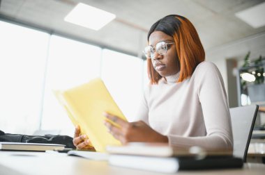 Sınıfta okuyan, üniversite ödevi üzerinde çalışan ciddi bir Afrikalı Amerikalı kız öğrenciye odaklanmış..