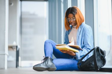 Öğrenci eğitimi, sınav hazırlığı, uzaktan öğrenme, eğitim konsepti. Güzel gülümseyen Afrikalı Amerikalı öğrenci.