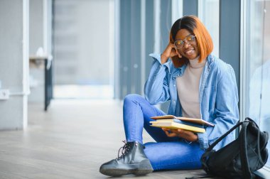 Öğrenci eğitimi, sınav hazırlığı, uzaktan öğrenme, eğitim konsepti. Güzel gülümseyen Afrikalı Amerikalı öğrenci.