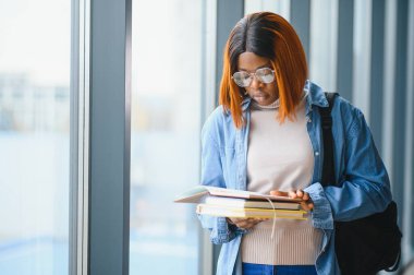 Öğrenci eğitimi, sınav hazırlığı, uzaktan öğrenme, eğitim konsepti. Güzel gülümseyen Afrikalı Amerikalı öğrenci.