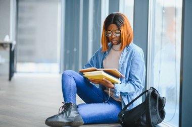 Öğrenci eğitimi, sınav hazırlığı, uzaktan öğrenme, eğitim konsepti. Güzel gülümseyen Afrikalı Amerikalı öğrenci.