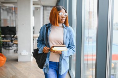 Öğrenci eğitimi, sınav hazırlığı, uzaktan öğrenme, eğitim konsepti. Güzel gülümseyen Afrikalı Amerikalı öğrenci.